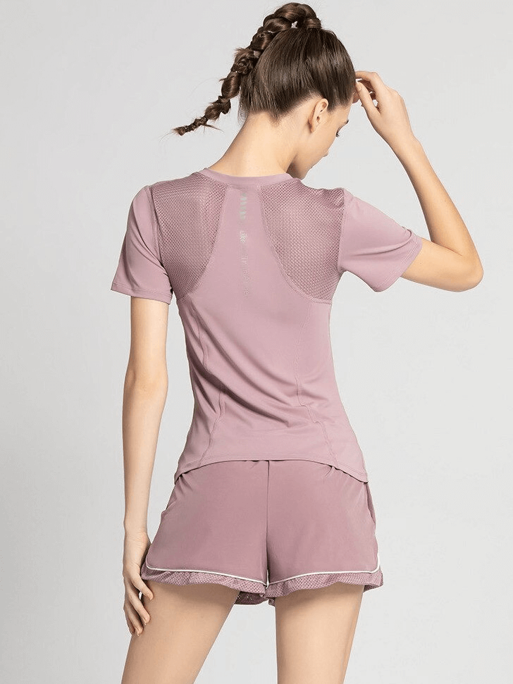Back view of woman wearing pink quick-dry athletic t-shirt with mesh back, round neck, perfect for yoga and sports.